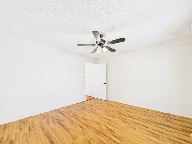 spare room with light wood-style flooring, a ceiling fan, and a textured ceiling