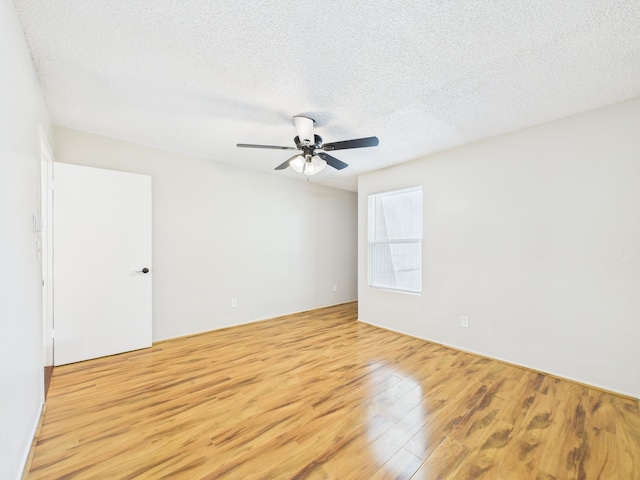 empty room featuring a textured ceiling, wood finished floors, and a ceiling fan