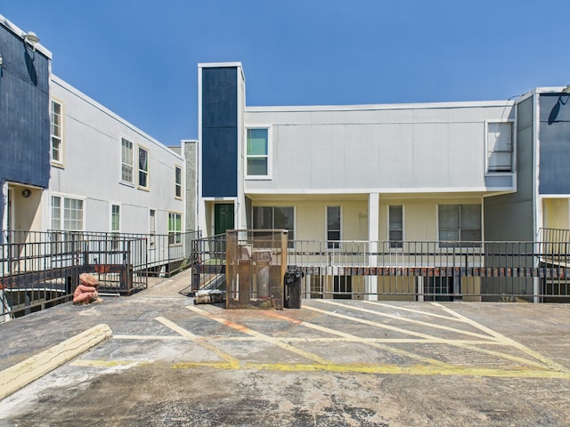 back of house with uncovered parking