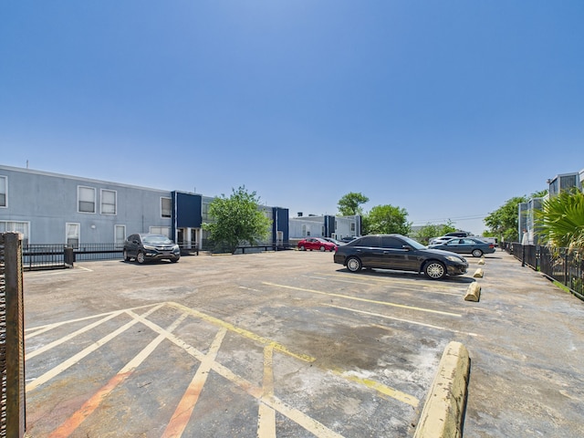 uncovered parking lot featuring fence