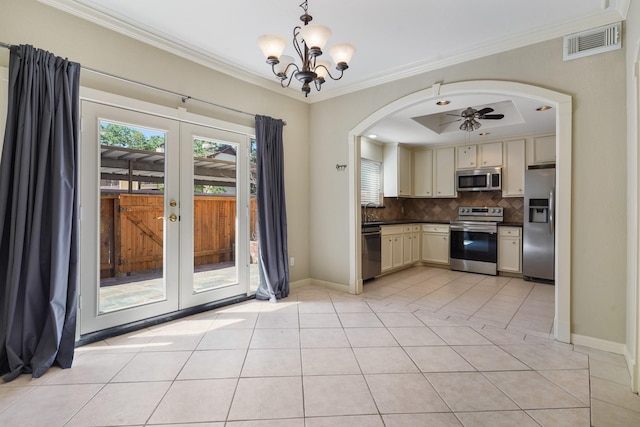 11711 Memorial Dr Unit 367, Houston, TX 77024 - kitchen featuring cream cabinets, dark countertops, visible vents, stainless steel appliances, and arched walkways