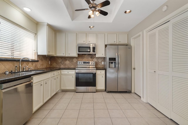 11711 Memorial Dr Unit 367, Houston, TX 77024 - kitchen featuring a sink, dark countertops, stainless steel appliances, backsplash, and cream cabinets