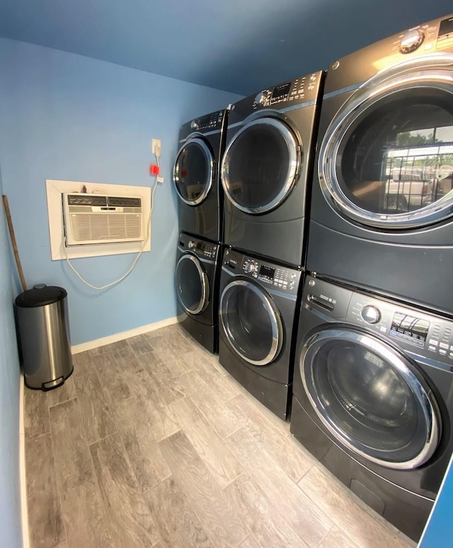 3522 Sampson St, Houston, TX 77004 - laundry room featuring baseboards, washer and dryer, an AC wall unit, stacked washing maching and dryer, and wood finished floors