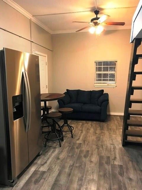 3522 Sampson St, Houston, TX 77004 - living area with a ceiling fan, wood finished floors, stairs, and ornamental molding