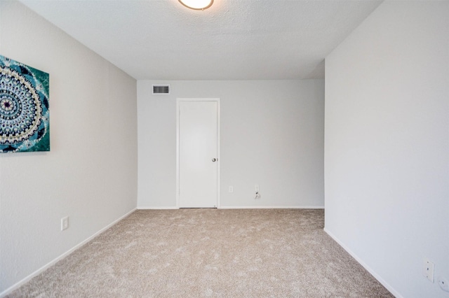 empty room with visible vents, baseboards, and carpet