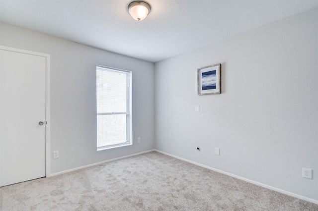 carpeted empty room with baseboards