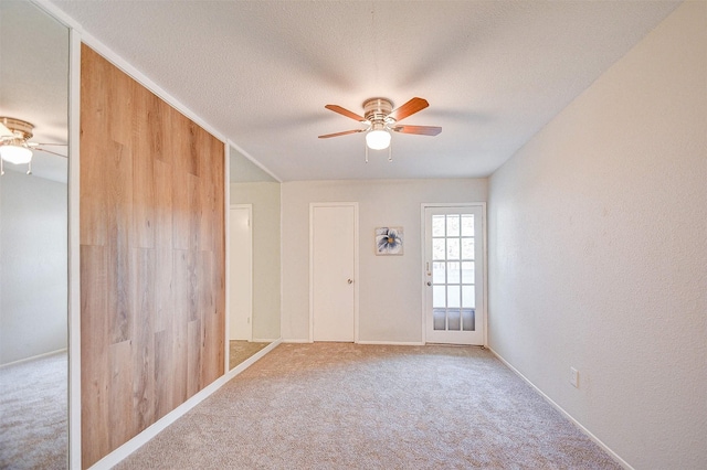 carpeted spare room with baseboards and ceiling fan