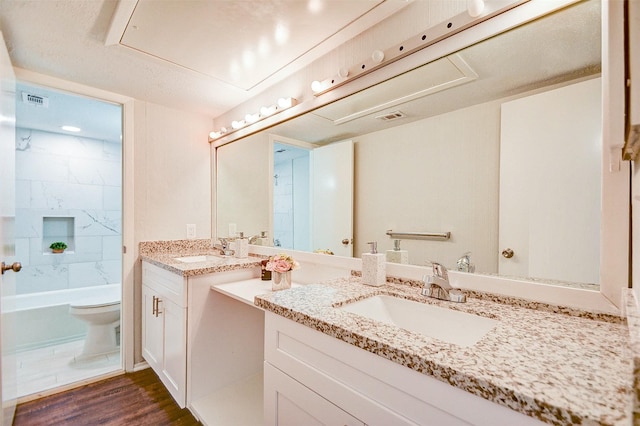 bathroom featuring visible vents, toilet, tub / shower combination, vanity, and wood finished floors