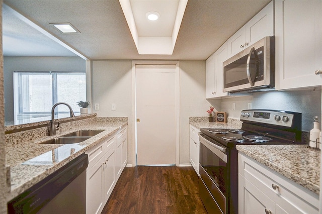 kitchen with stainless steel appliances, dark wood-style flooring, white cabinetry, and a sink