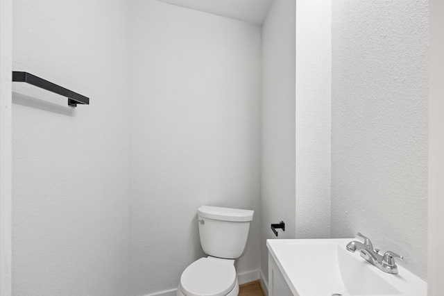 bathroom with vanity, baseboards, and toilet