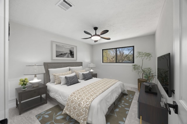 carpeted bedroom with visible vents and ceiling fan