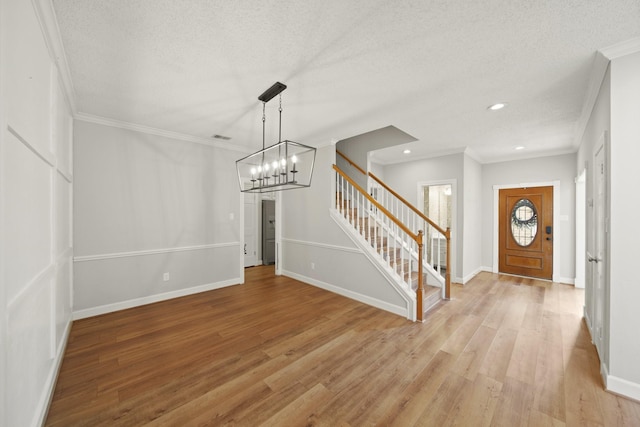 2331 Sand Ct, Richmond, TX 77406 - foyer entrance with a chandelier, stairs, light wood finished floors, and ornamental molding