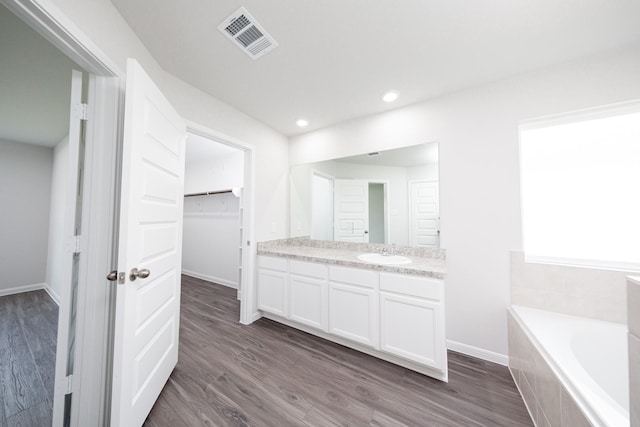 16547 Willow Forest Dr, Conroe, TX 77302 - bathroom with vanity, a garden tub, wood finished floors, a spacious closet, and recessed lighting