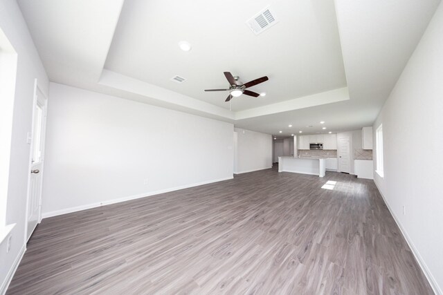 16547 Willow Forest Dr, Conroe, TX 77302 - unfurnished living room with a tray ceiling, a ceiling fan, wood finished floors, and recessed lighting