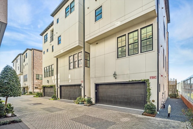 1 Robita St, Houston, TX 77019 - view of building exterior featuring an attached garage, decorative driveway, and fence