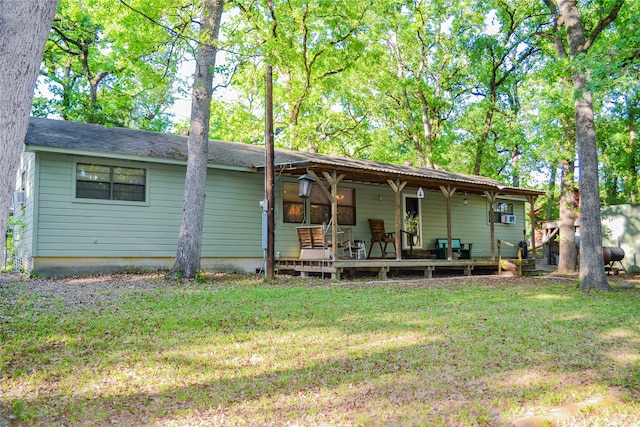 rear view of house with a yard and a porch
