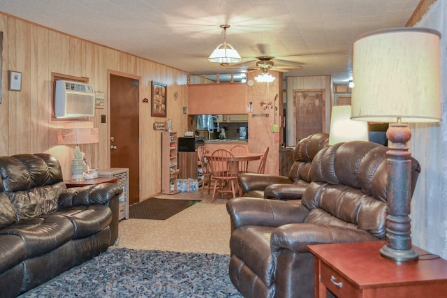 living room with wood walls, ceiling fan, carpet flooring, and a wall mounted AC