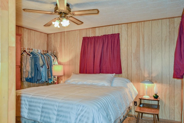 bedroom featuring wooden walls and a ceiling fan