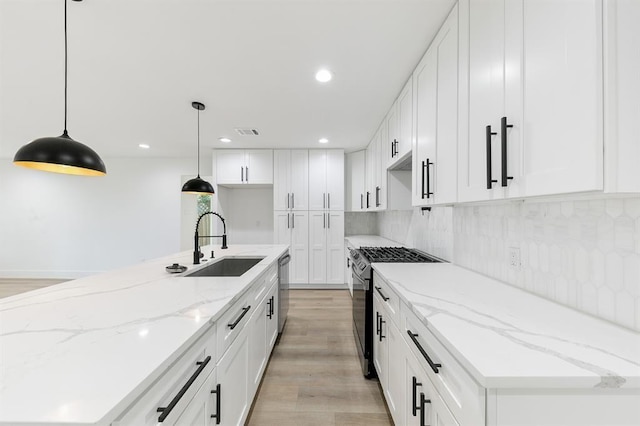 5338 Pease St, Houston, TX 77023 - kitchen with light wood-style flooring, visible vents, gas range, a sink, and backsplash