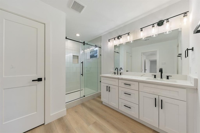 5338 Pease St, Houston, TX 77023 - bathroom with a shower stall, wood finished floors, a sink, and visible vents