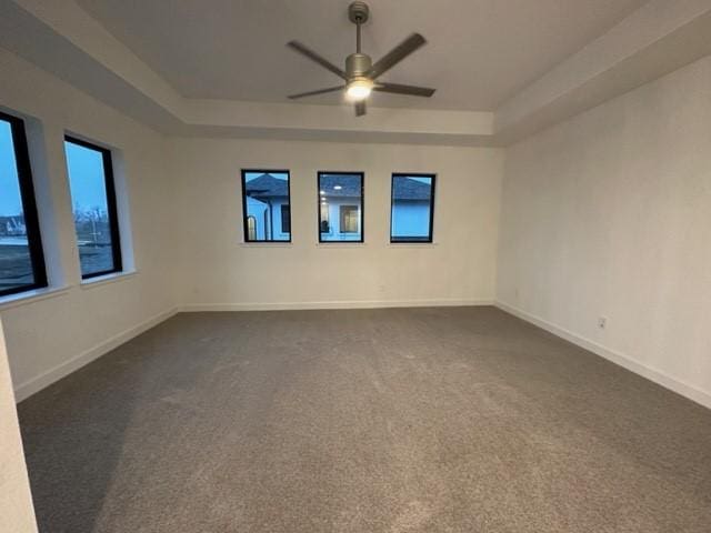9015 Orchard Cv, Missouri City, TX 77459 - unfurnished room with dark colored carpet, a ceiling fan, and a raised ceiling