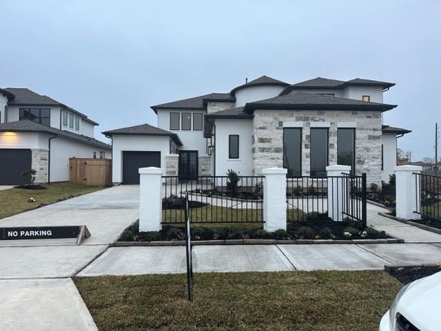 9015 Orchard Cv, Missouri City, TX 77459 - view of front of house featuring a garage, driveway, stucco siding, and a fenced front yard