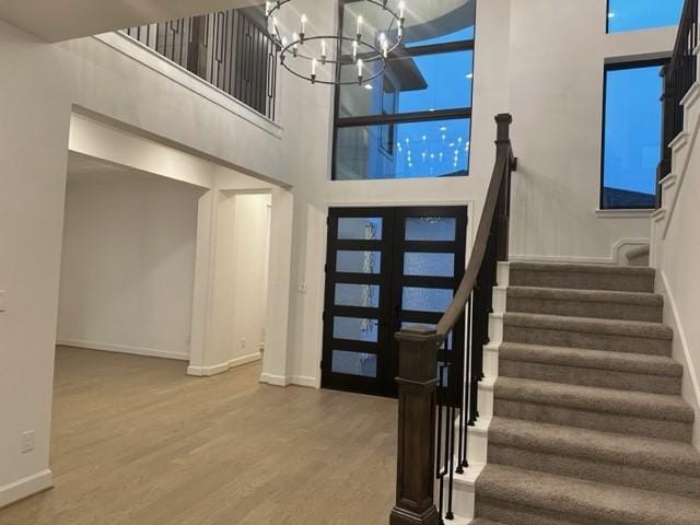 9015 Orchard Cv, Missouri City, TX 77459 - entryway featuring a chandelier, a high ceiling, baseboards, and wood finished floors