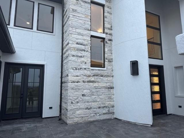 9015 Orchard Cv, Missouri City, TX 77459 - exterior space featuring french doors, stucco siding, and stone siding
