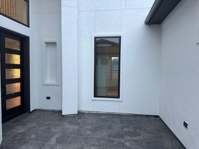 9015 Orchard Cv, Missouri City, TX 77459 - doorway to property featuring stucco siding