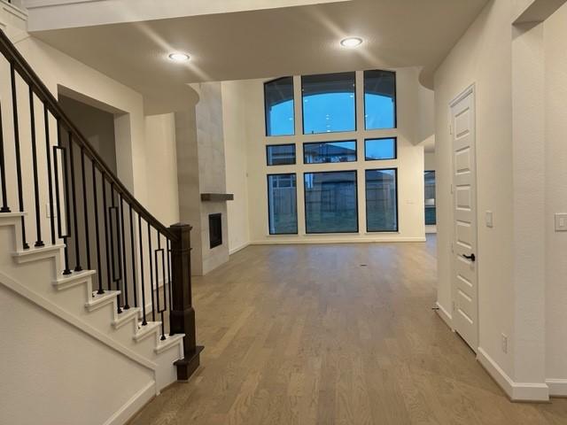 9015 Orchard Cv, Missouri City, TX 77459 - interior space with a large fireplace, baseboards, recessed lighting, stairs, and wood finished floors
