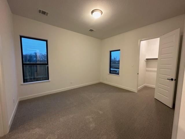 9015 Orchard Cv, Missouri City, TX 77459 - unfurnished bedroom featuring visible vents, baseboards, and dark colored carpet