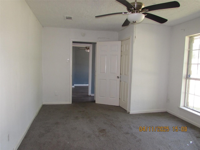 unfurnished room with carpet floors, a wealth of natural light, and a ceiling fan