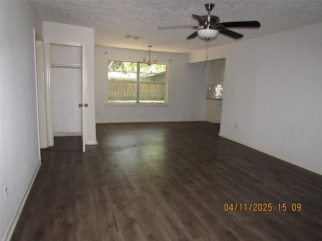 spare room with a textured ceiling, ceiling fan, visible vents, and dark wood-style flooring
