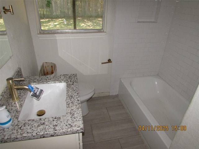 full bath featuring toilet, vanity, and plenty of natural light