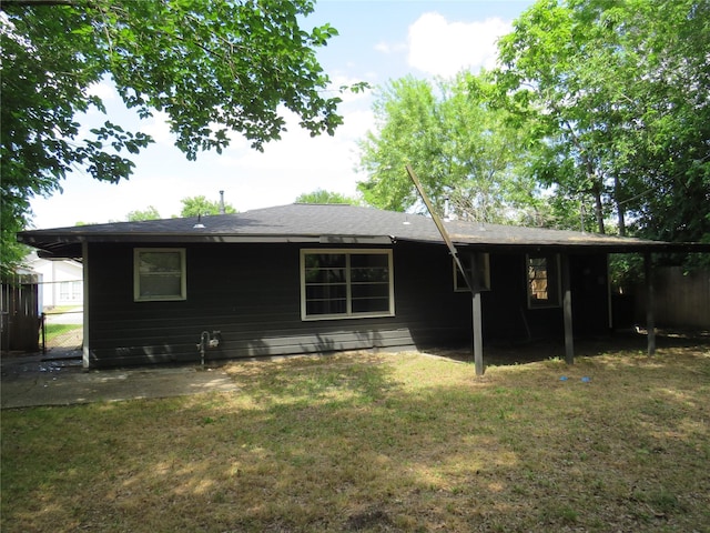 rear view of house with a yard and fence