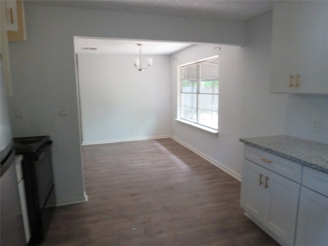 unfurnished dining area featuring a notable chandelier, dark wood-style floors, and baseboards