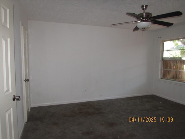 carpeted spare room featuring a textured ceiling, ceiling fan, and baseboards