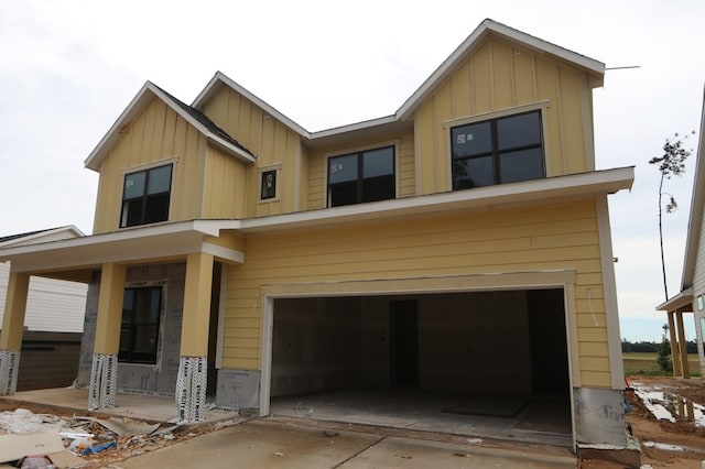 16146 Rita Rd, Conroe, TX 77302 - view of front of house with board and batten siding, an attached garage, covered porch, and driveway