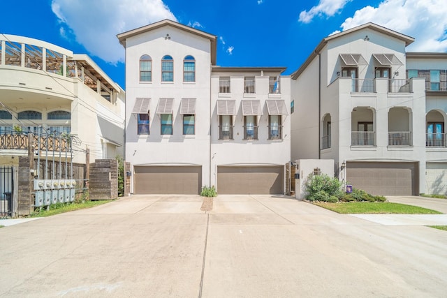 view of front facade featuring concrete driveway, a garage, and stucco siding