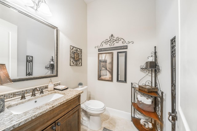 half bath with vanity, toilet, and baseboards