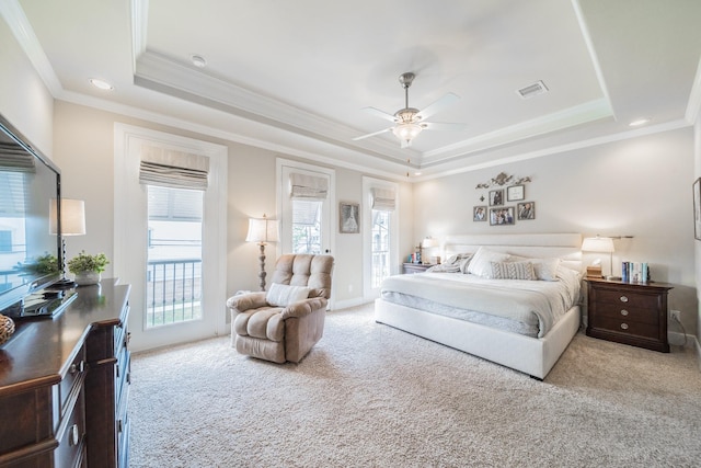 carpeted bedroom with visible vents, crown molding, a tray ceiling, and access to exterior