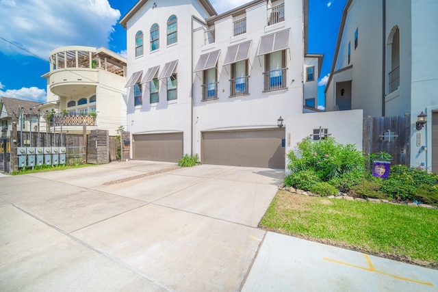 view of front facade featuring stucco siding, concrete driveway, and a garage