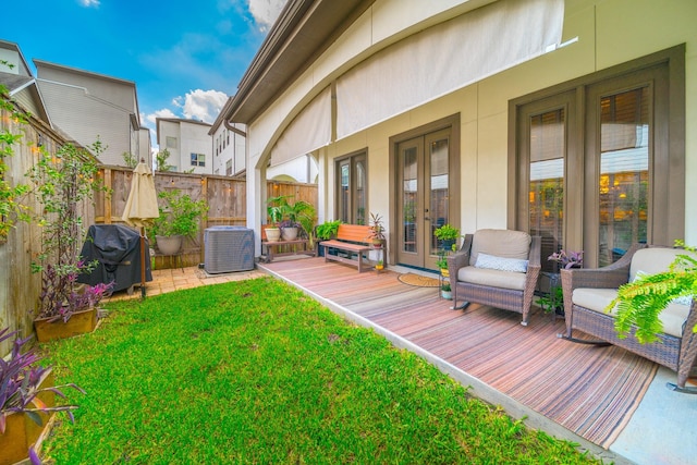 exterior space featuring central AC unit, a yard, area for grilling, french doors, and fence