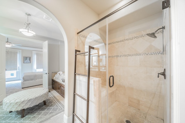 ensuite bathroom with connected bathroom, ceiling fan, vanity, visible vents, and a stall shower
