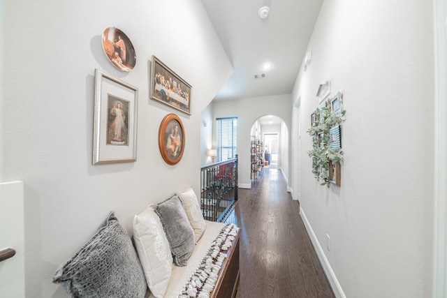 hall with dark wood-style floors, recessed lighting, visible vents, baseboards, and arched walkways
