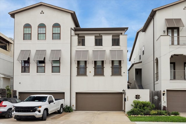 townhome / multi-family property with stucco siding, concrete driveway, and an attached garage