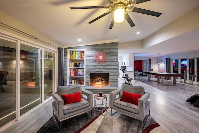 interior space with a stone fireplace, ceiling fan, recessed lighting, wood finished floors, and pool table