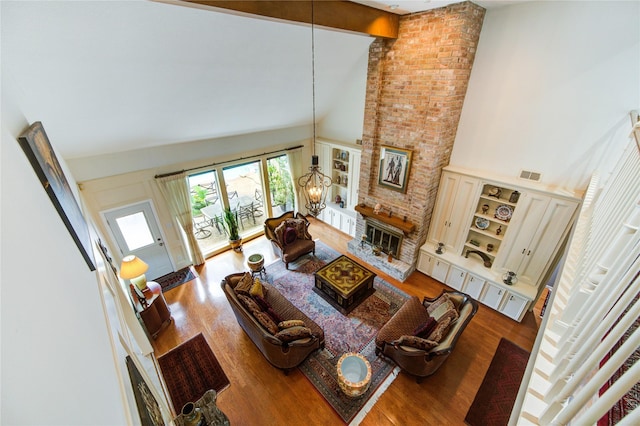 16123 Chasemore Dr, Spring, TX 77379 - living area with high vaulted ceiling, a chandelier, wood finished floors, a brick fireplace, and beamed ceiling