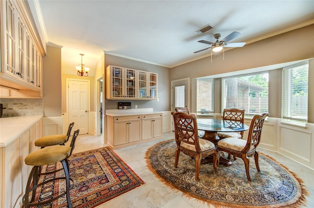 16123 Chasemore Dr, Spring, TX 77379 - dining area with ornamental molding, ceiling fan, a chandelier, wainscoting, and a decorative wall