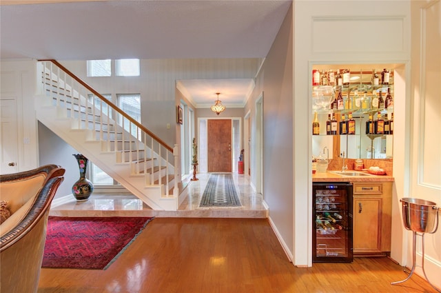 16123 Chasemore Dr, Spring, TX 77379 - entryway with wine cooler, bar, stairway, light wood-type flooring, and baseboards
